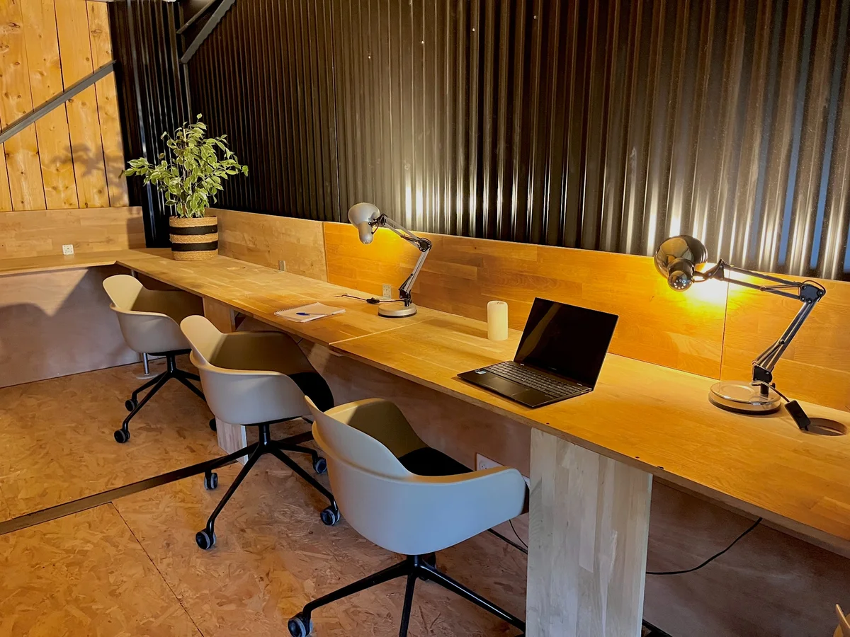 Postes de travail partagés avec grandes tables en bois chez K'Hub